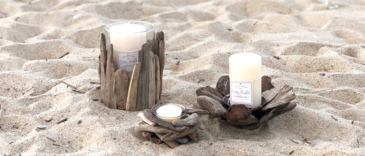 Driftwood beachy accessories with white gardenia pillar and votive candles on the beach